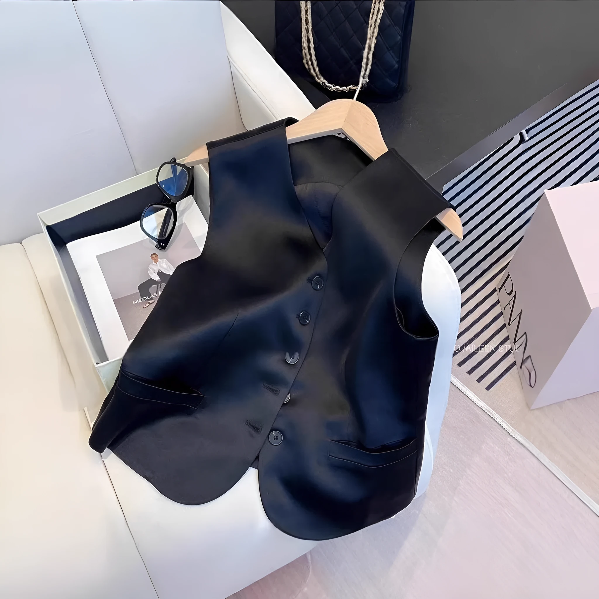 Black satin ladies sleeveless vest with V-neck and loose fit on a hanger.