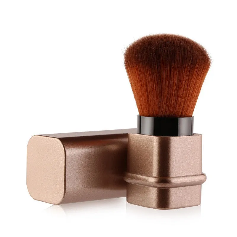 Portable single makeup brush with man-made fibre bristles and square gold plastic handle on white background