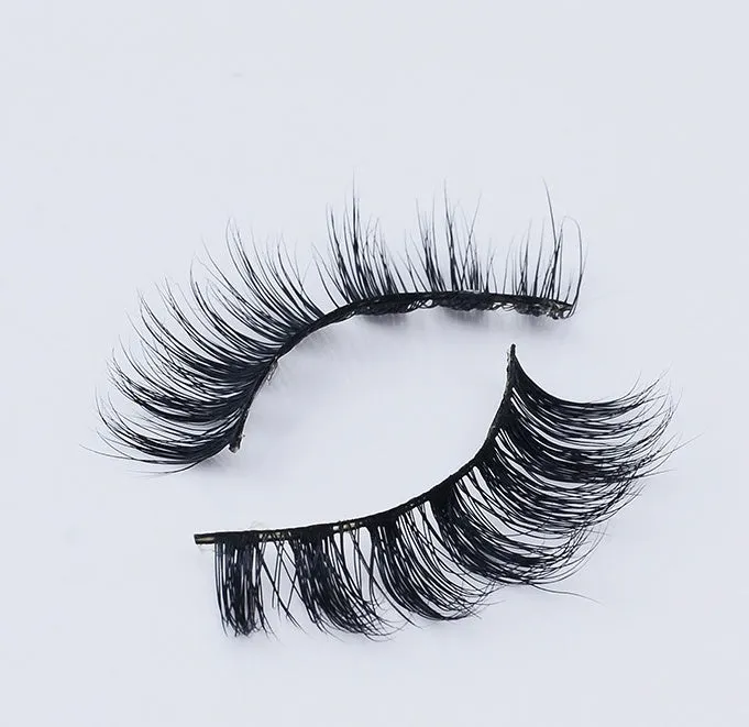 Pair of faux mink eyelashes with long tail and cotton stem against white background