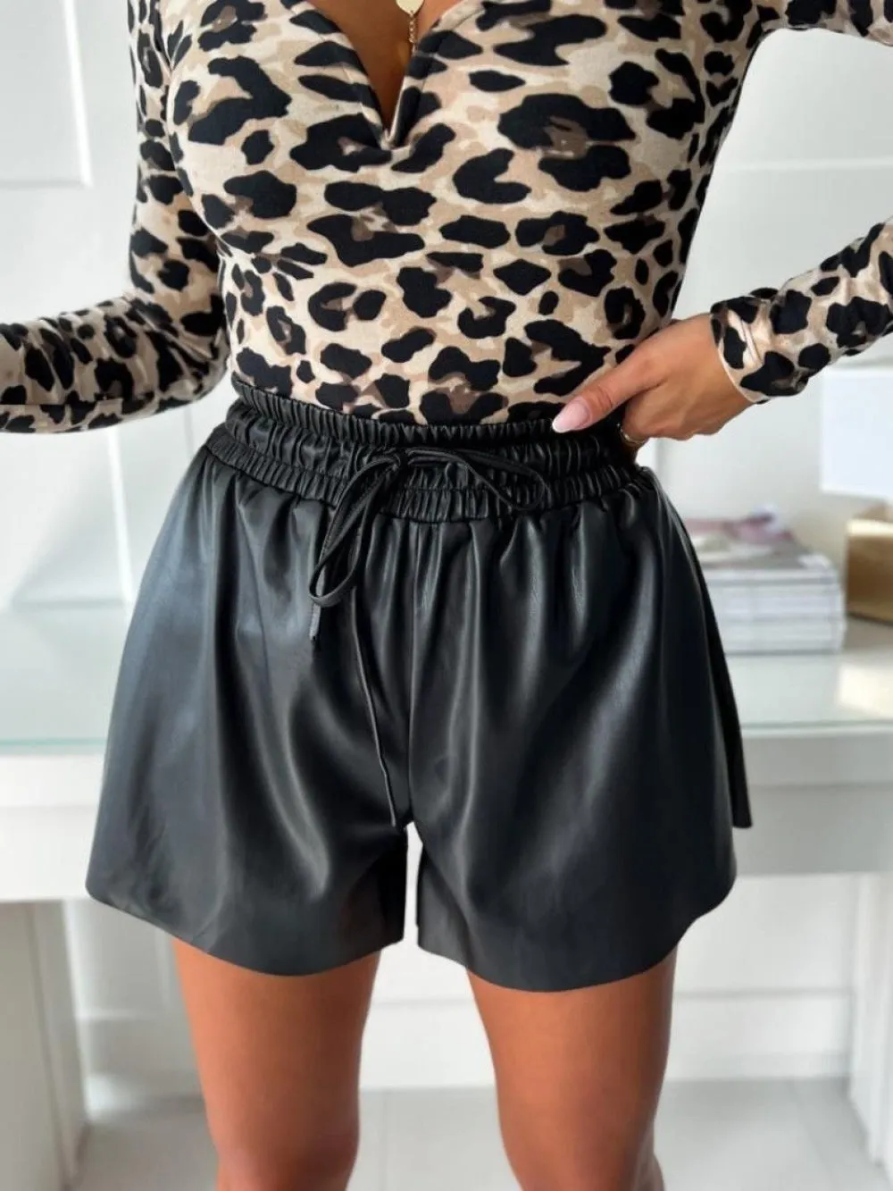 Women's black drawstring lace-up wide-leg casual shorts made of PU leather-look fabric.
