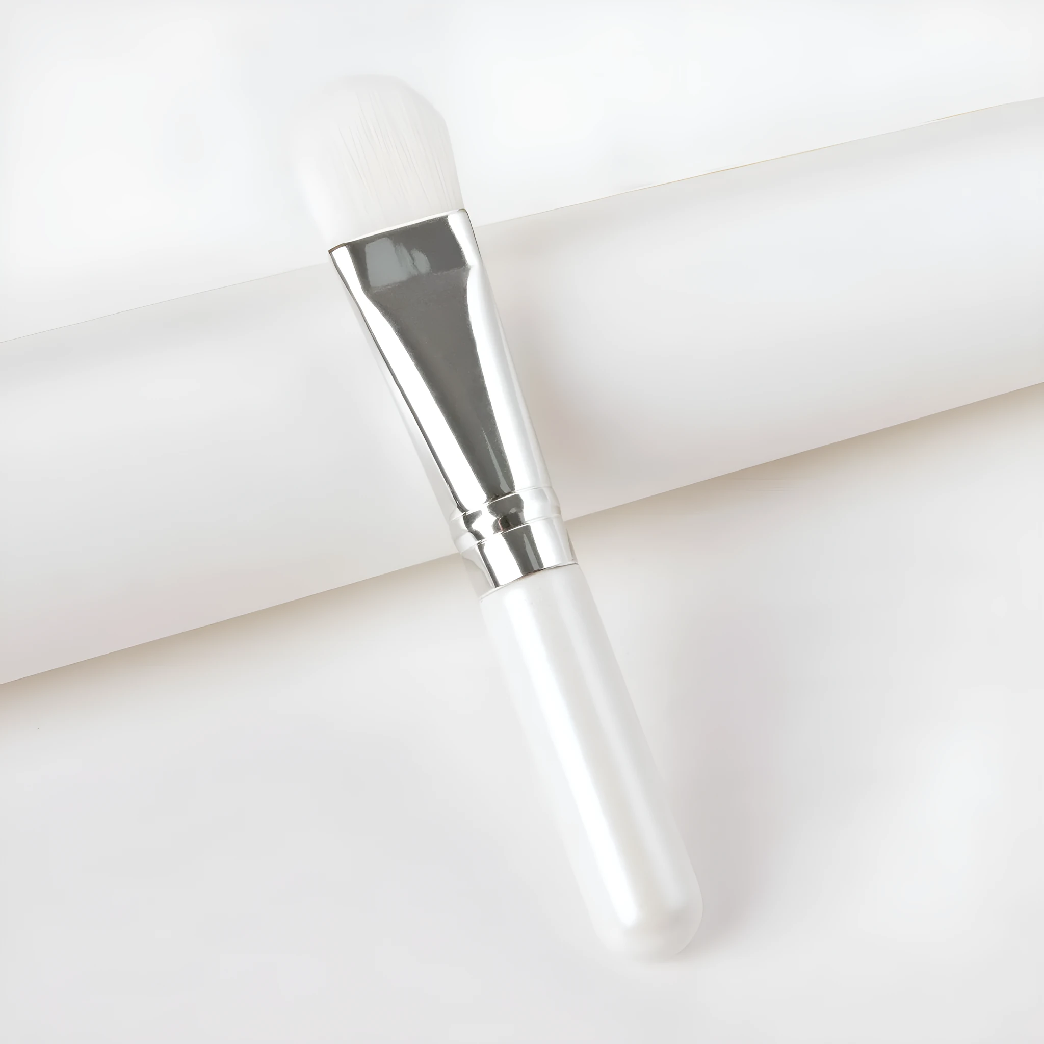 Wooden handle portable facial treatment brush with artificial fibre bristles on white background