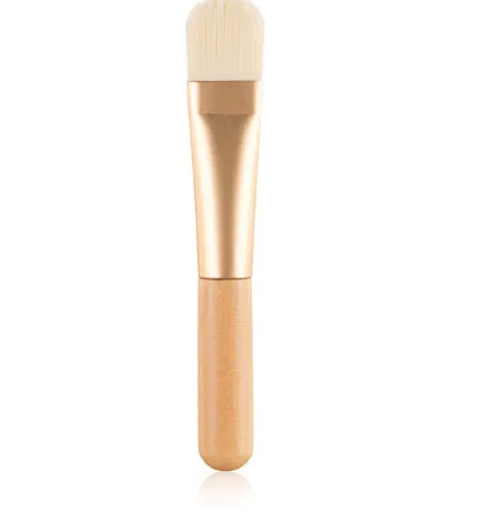Wooden handle portable facial treatment brush with artificial fibre bristles on white background