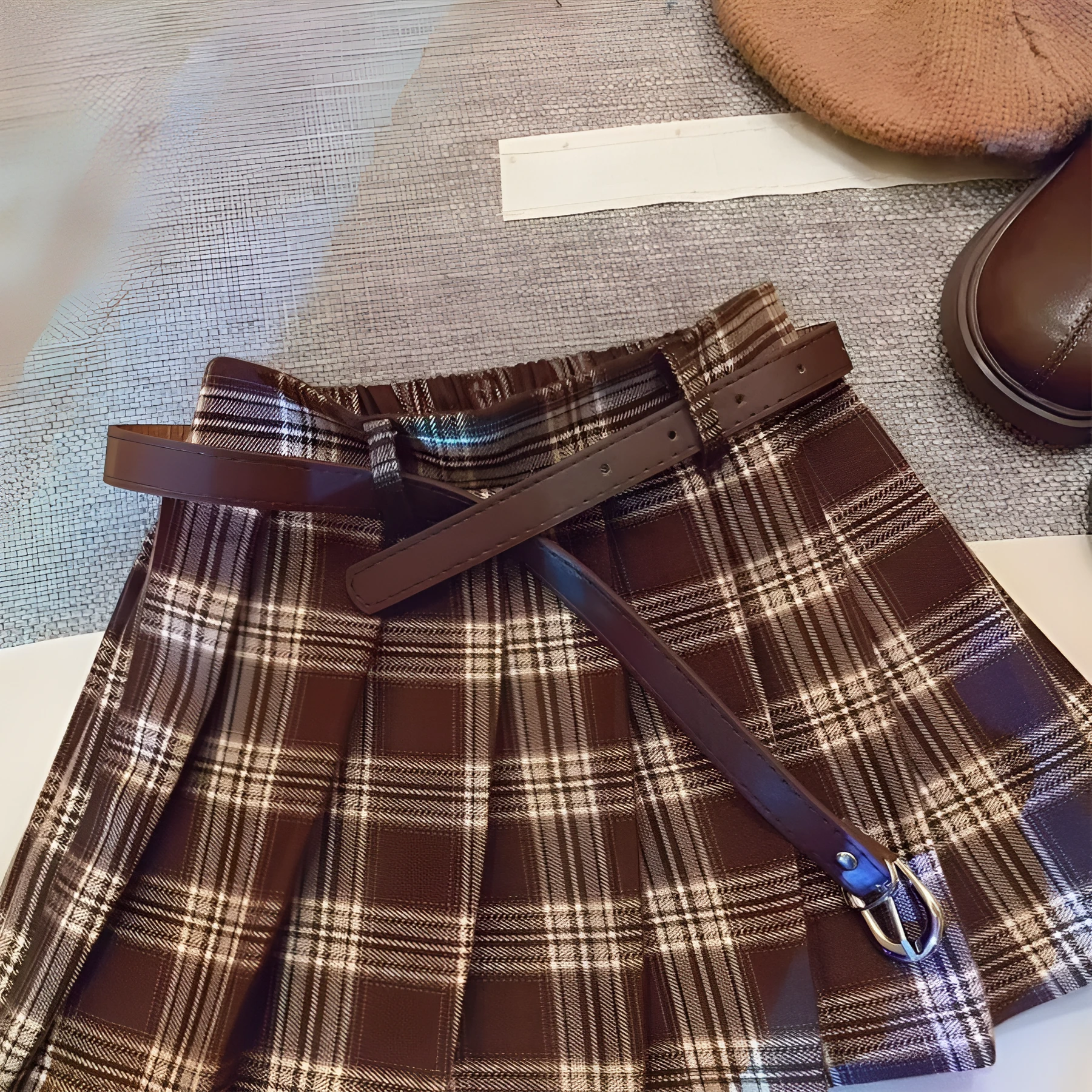 Girls cotton plaid pleated A-line skirt on a hanger, showing its length and pattern.