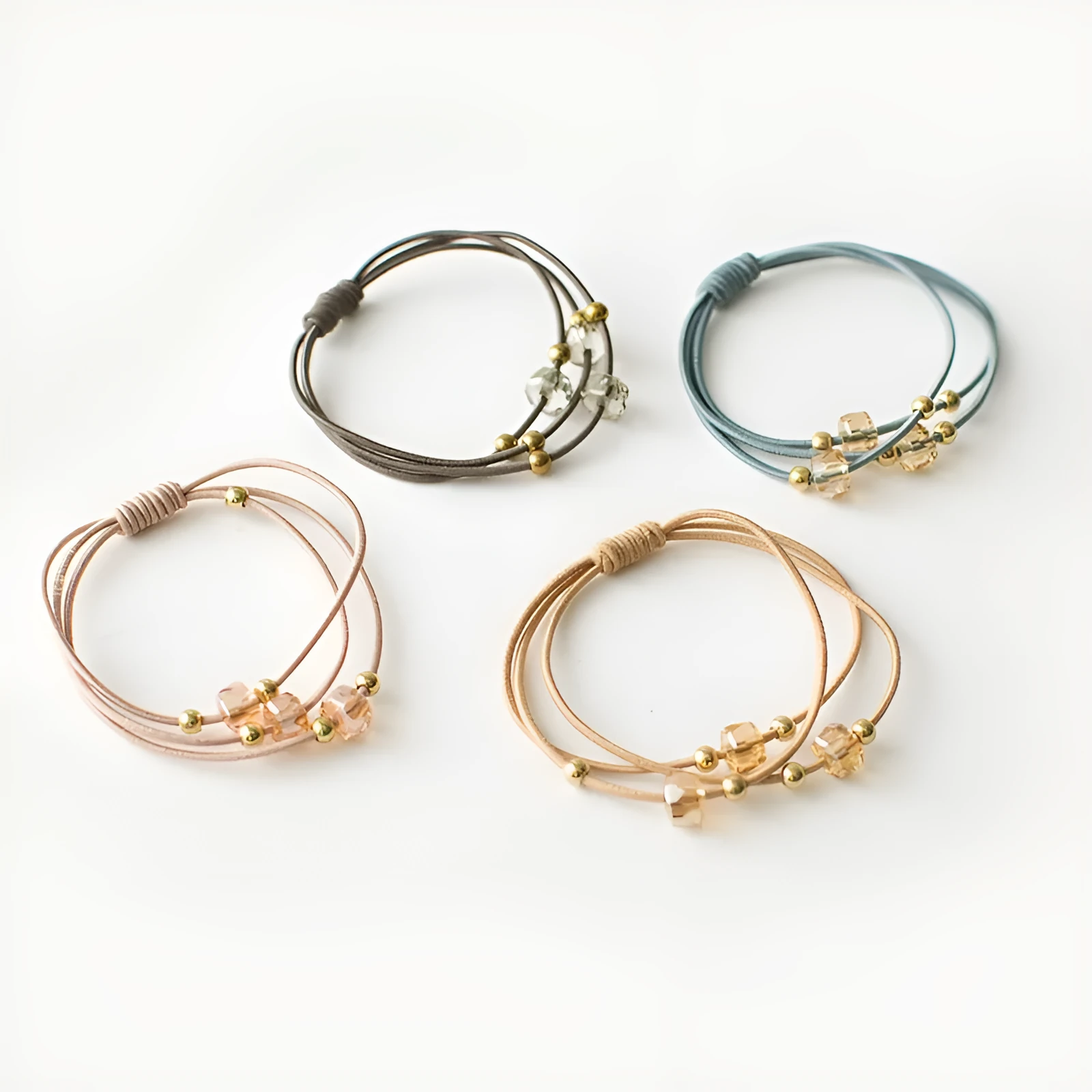 Crystal string beads rubber knotted hair band with octagonal electroplated beads in matte golden, on a plain background.