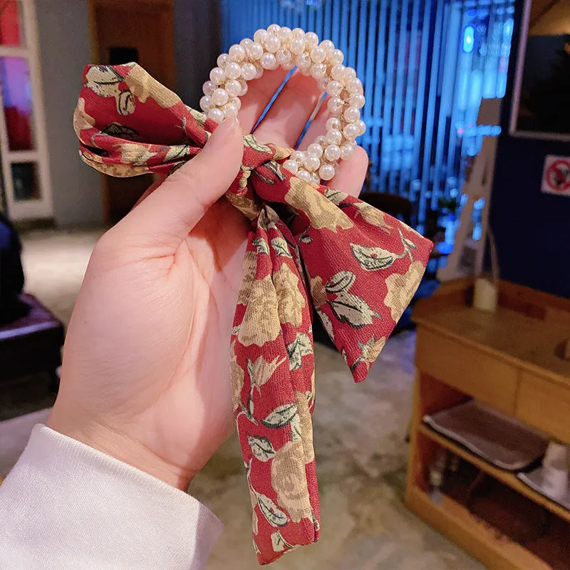 Pearl hair tie with bowknot and broken flower design in cloth material, available in multiple ribbon colours