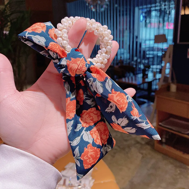 Pearl hair tie with bowknot and broken flower design in cloth material, available in multiple ribbon colours