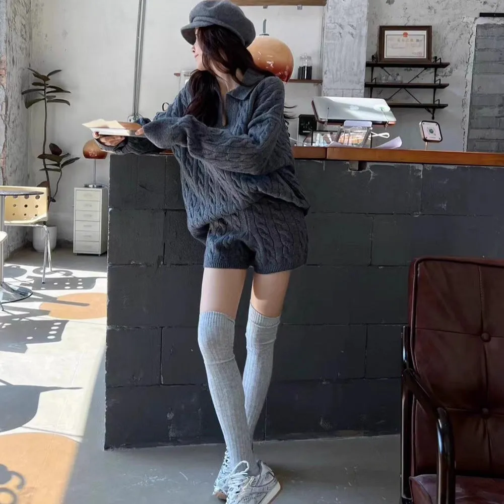 Women's creamy-white cable knit sweater and shorts set with an elasticated waistband laid flat.
