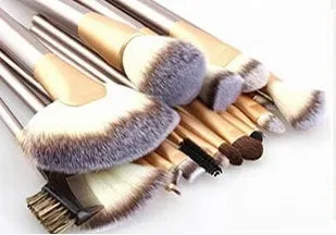 Champagne white synthetic fibre makeup brush set with wooden handles and aluminium ferrules on flat surface