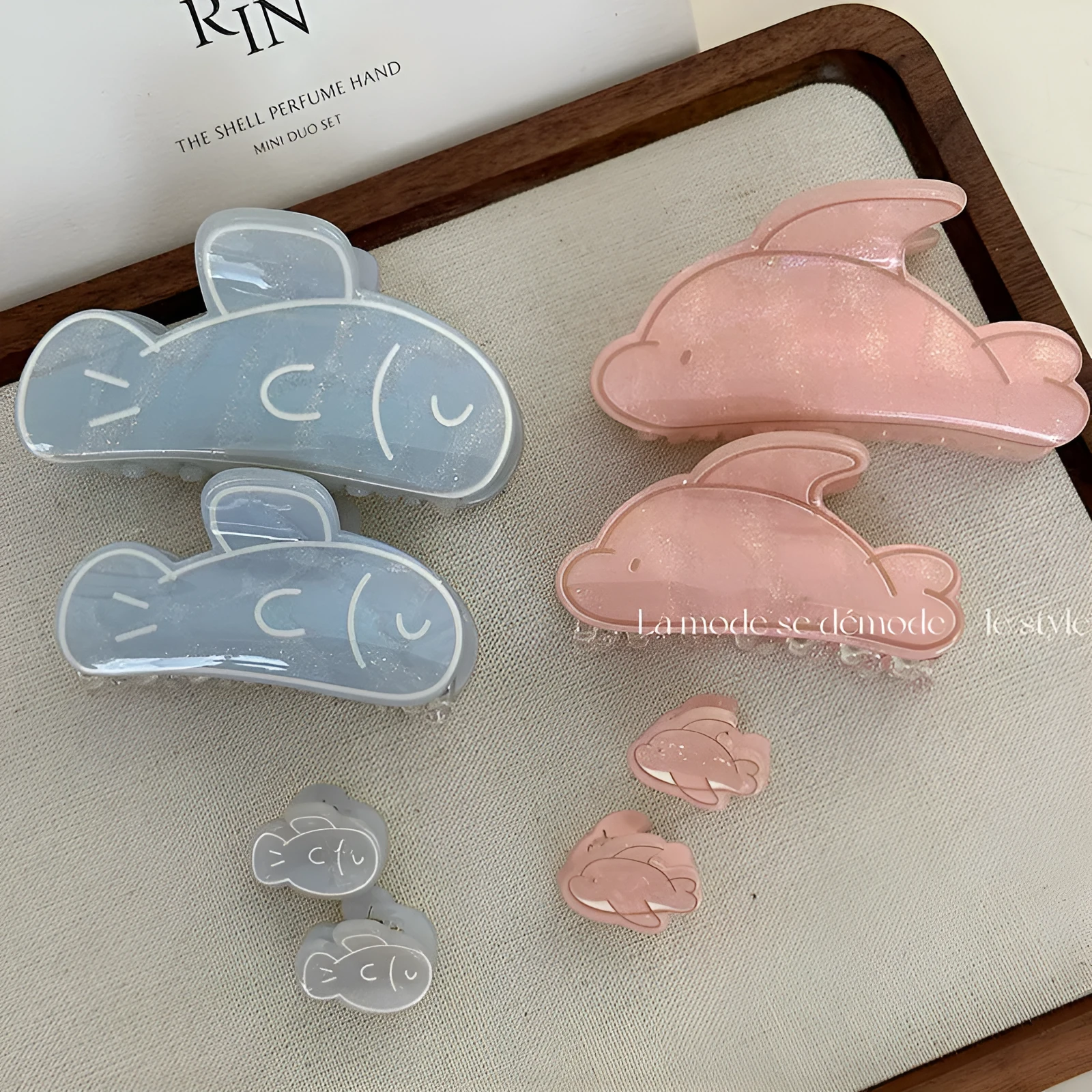 Women's dolphin grabber clip headdress in acetate material, available in blue and pink sizes, styled on hair