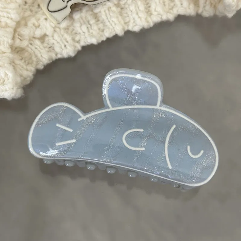Women's dolphin grabber clip headdress in acetate material, available in blue and pink sizes, styled on hair