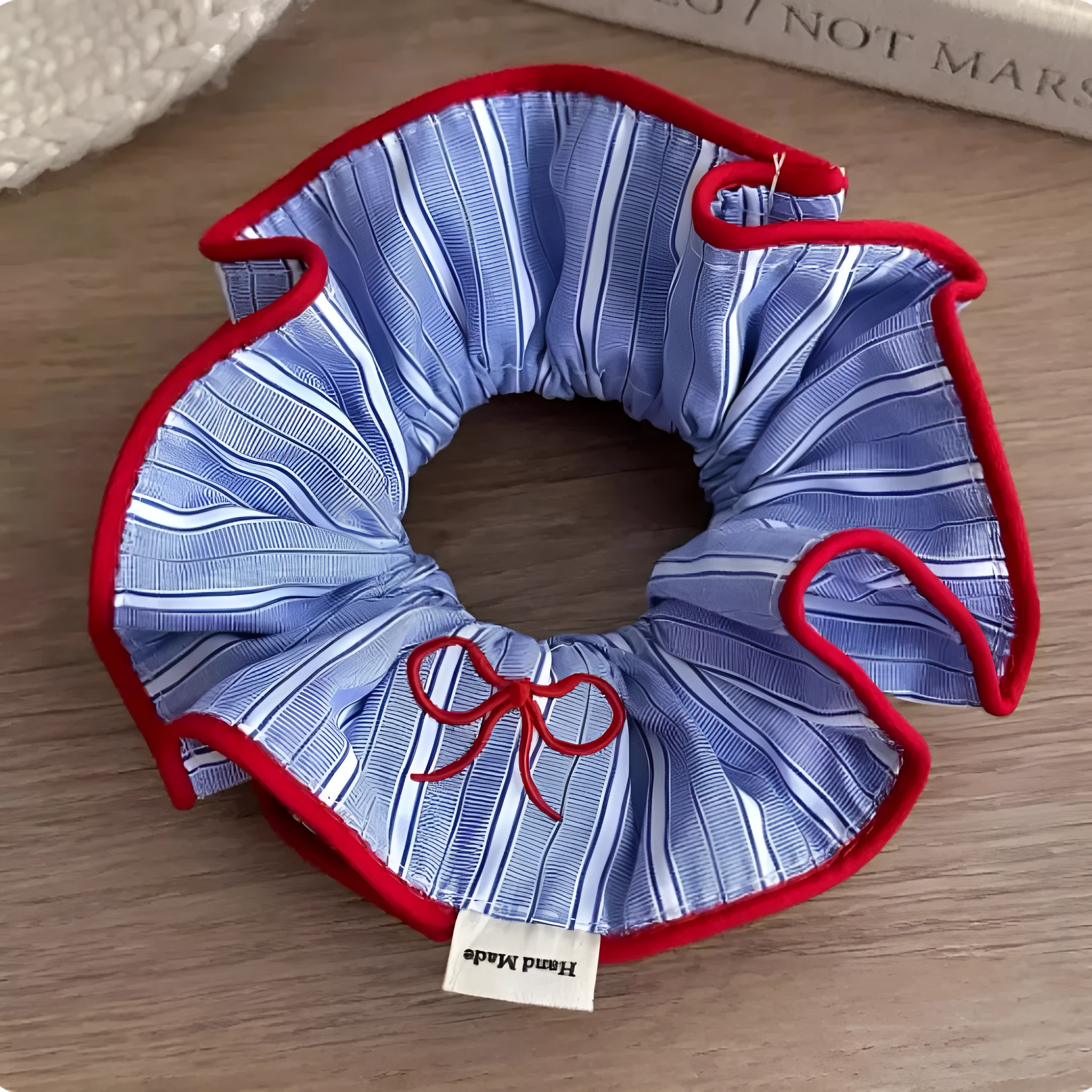 Blue striped fabric ball large intestine style stretch hairband on neutral background
