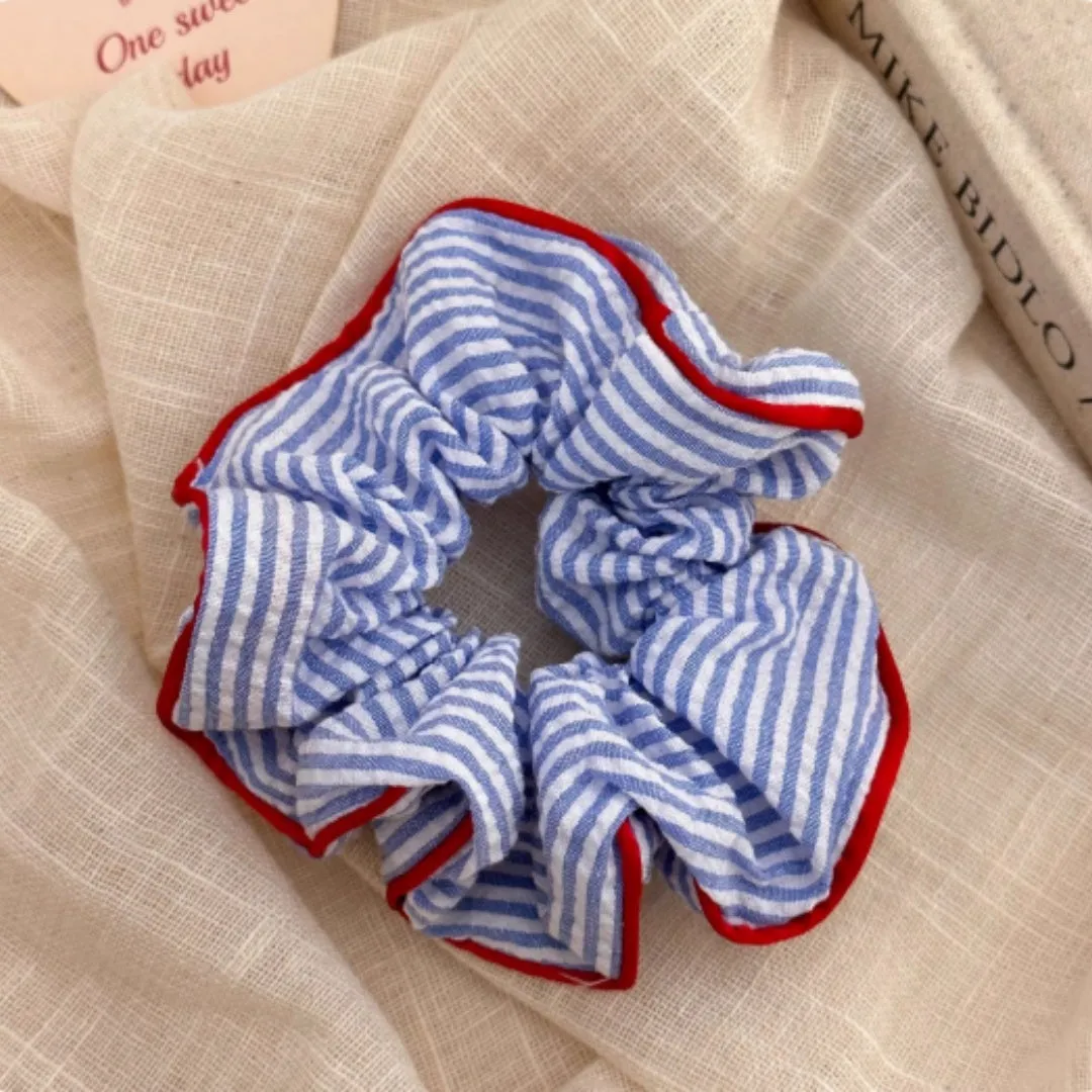 Blue striped fabric ball large intestine style stretch hairband on neutral background