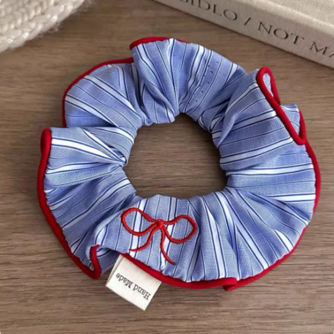 Blue striped fabric ball large intestine style stretch hairband on neutral background