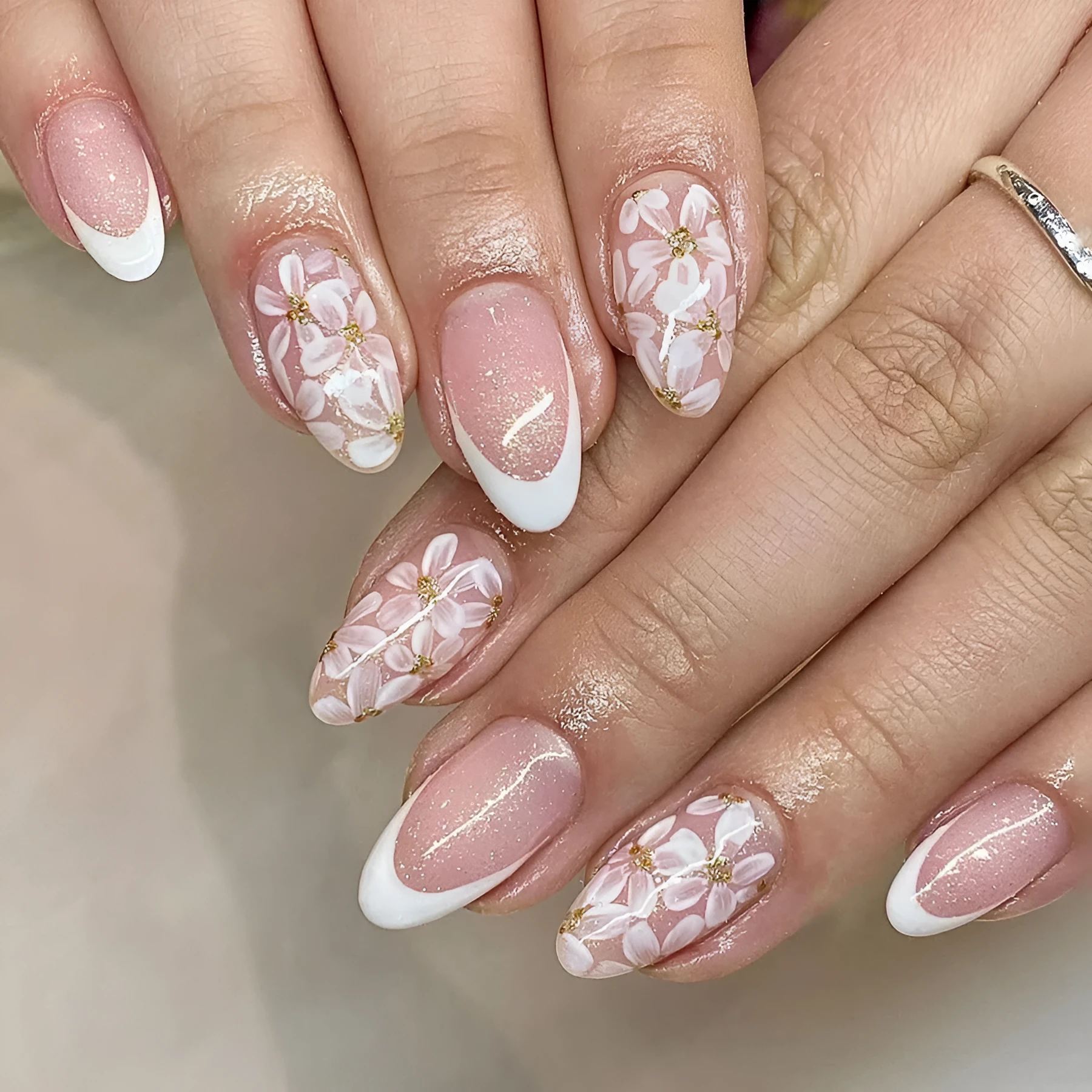 Short almond-shaped false nails with French style glitter and flower designs in colour C625