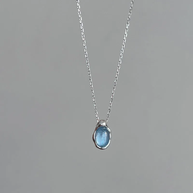 Geometric navy blue water drop pendant necklace on an adjustable copper chain.