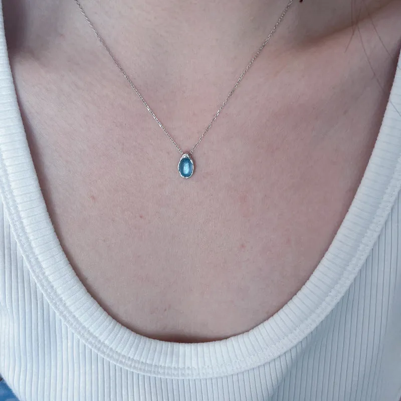 Geometric navy blue water drop pendant necklace on an adjustable copper chain.