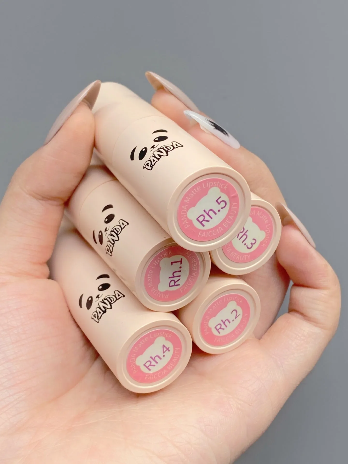 Little white tube matte velvet lipstick with five colour swatches Almond Cinnamon, Amber orange brown, Dirty Orange, Jujube Red Brown, White Peach Bean Paste