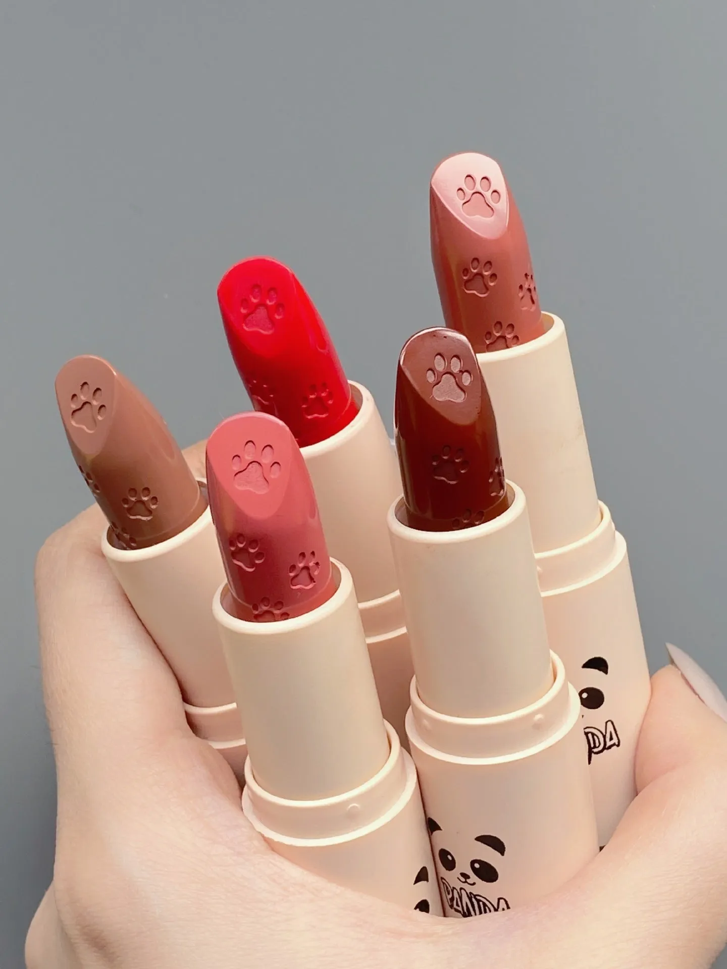 Little white tube matte velvet lipstick with five colour swatches Almond Cinnamon, Amber orange brown, Dirty Orange, Jujube Red Brown, White Peach Bean Paste