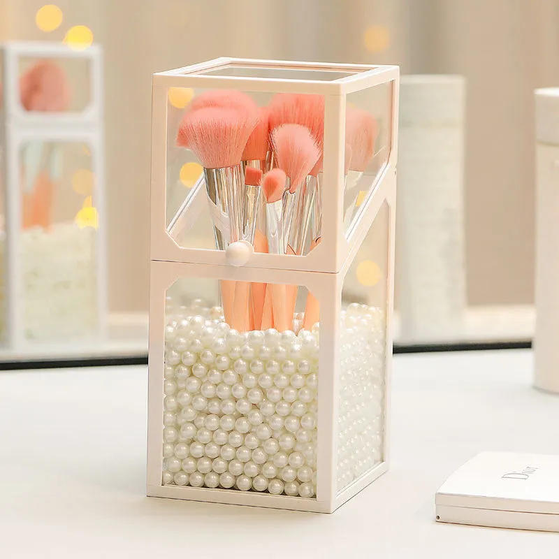 Transparent glass makeup brush bucket with black lid on white surface showing brushes inside