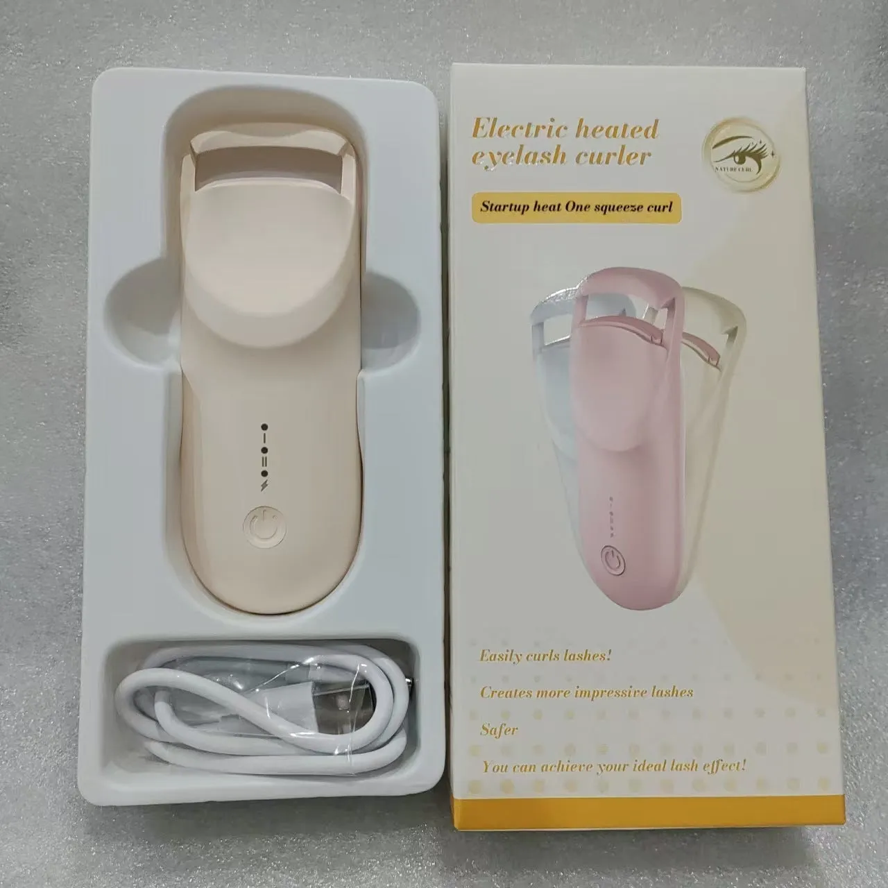 Electric USB-rechargeable eyelash curler in cream white, pink, and apricot colour options.