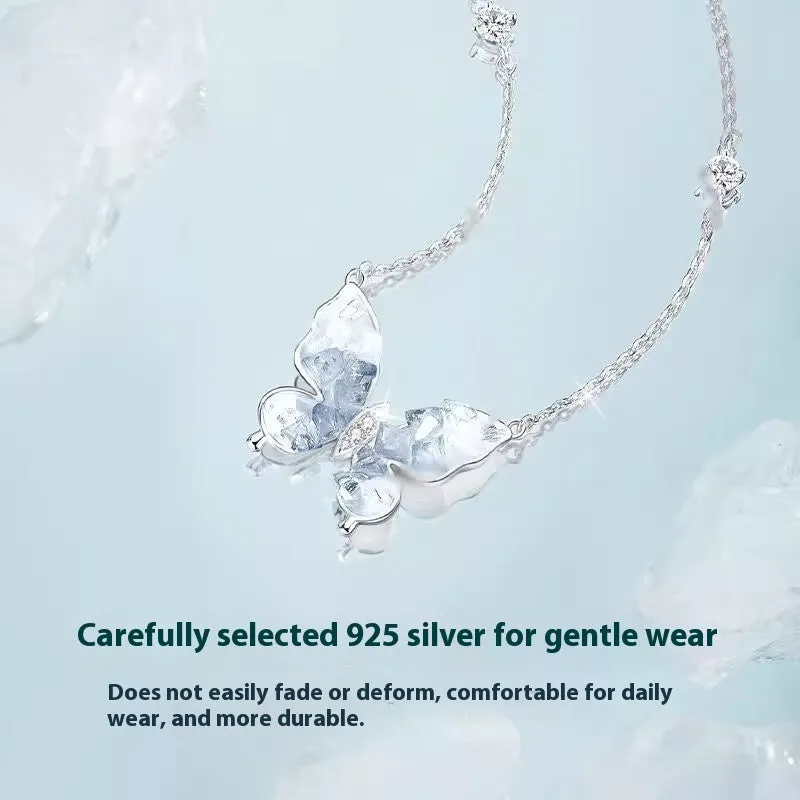 Close-up of a silver necklace with a detailed ice rain butterfly pendant on an O-ring chain.