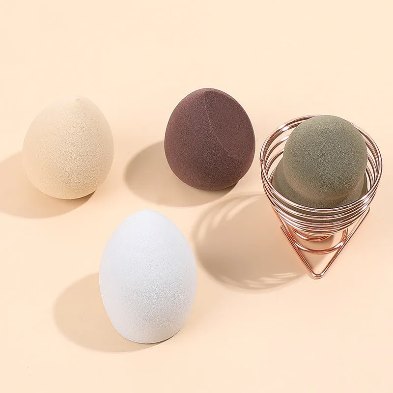 Four coloured hydrophilic polyurethane beauty eggs placed on a metal stand for makeup application