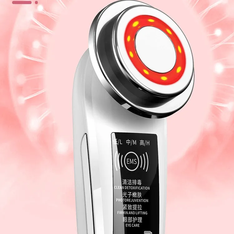 Pink and white rechargeable facial massager with red and blue light therapy functions on a clean surface