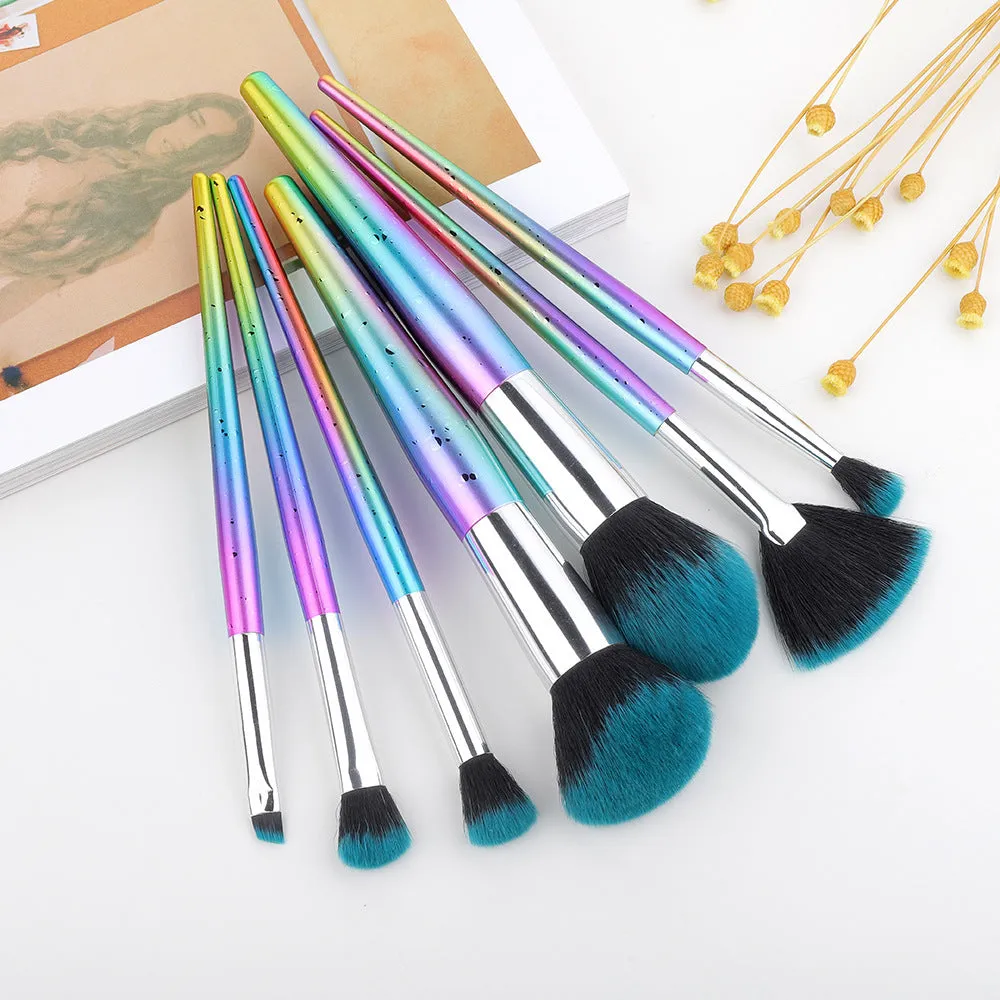 Water drop pattern makeup brush set of seven brushes with blue gold pink purple and transparent handles on white background