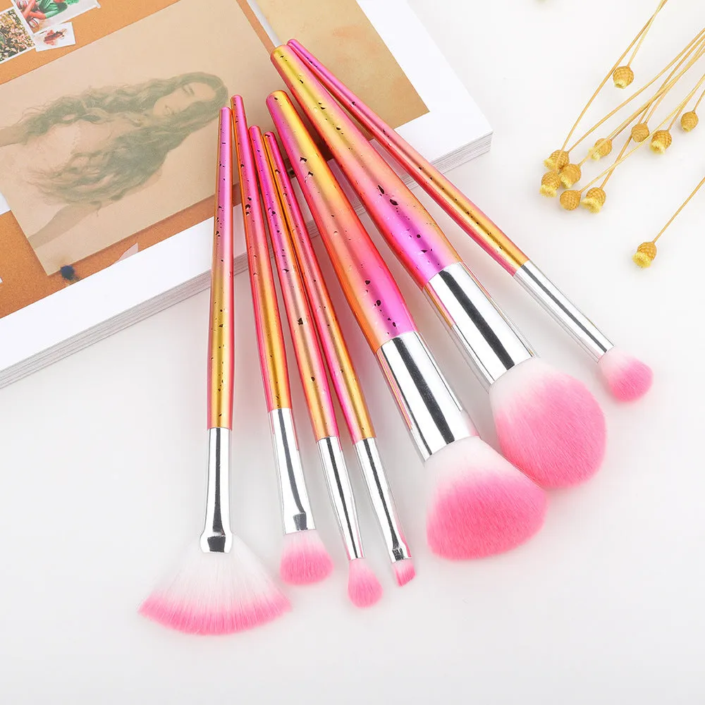 Water drop pattern makeup brush set of seven brushes with blue gold pink purple and transparent handles on white background