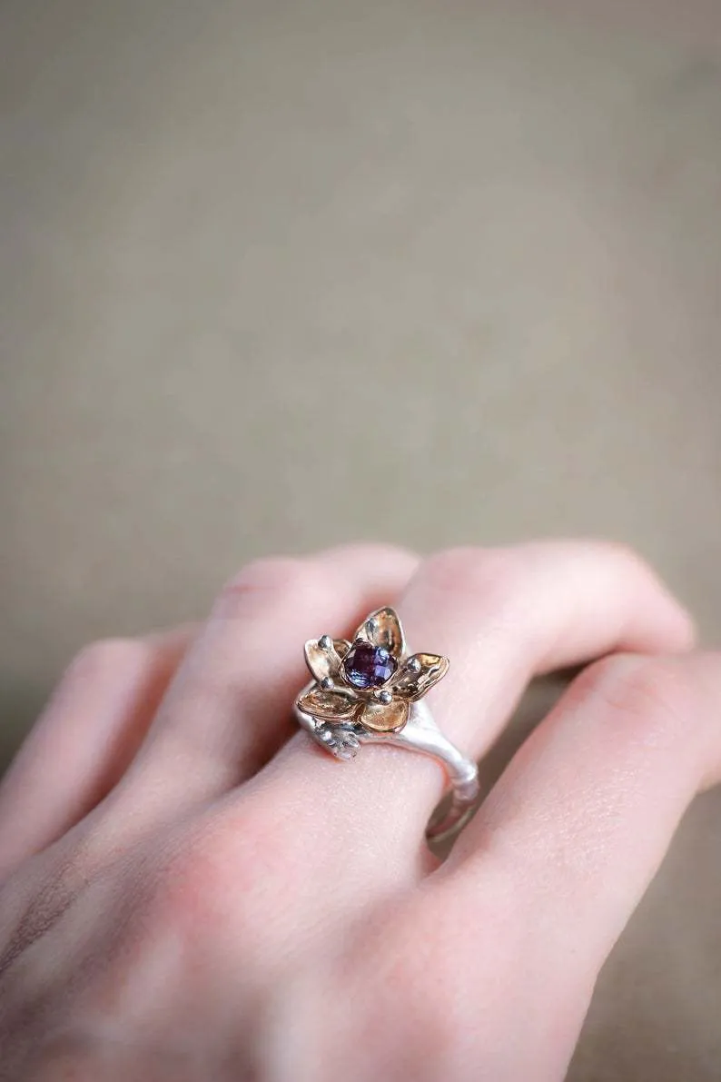 A two-tone silver women's ring with a geometric band and a floral ornament.