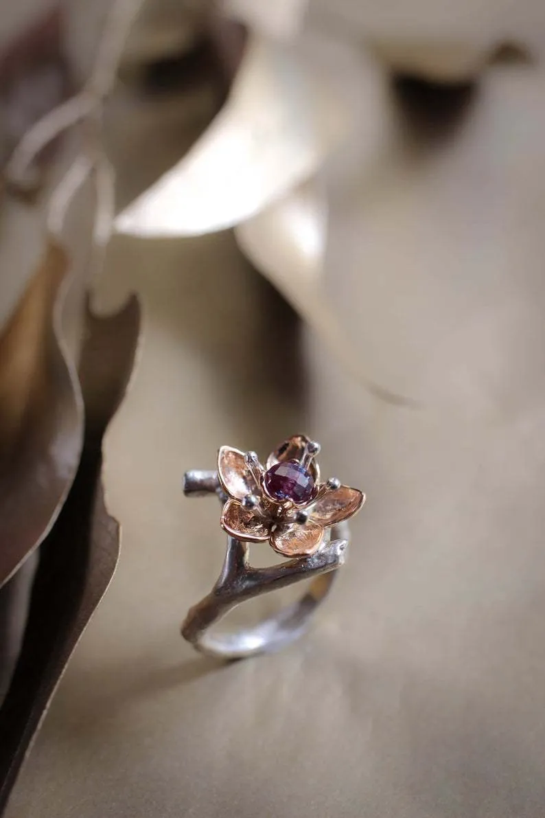 A two-tone silver women's ring with a geometric band and a floral ornament.