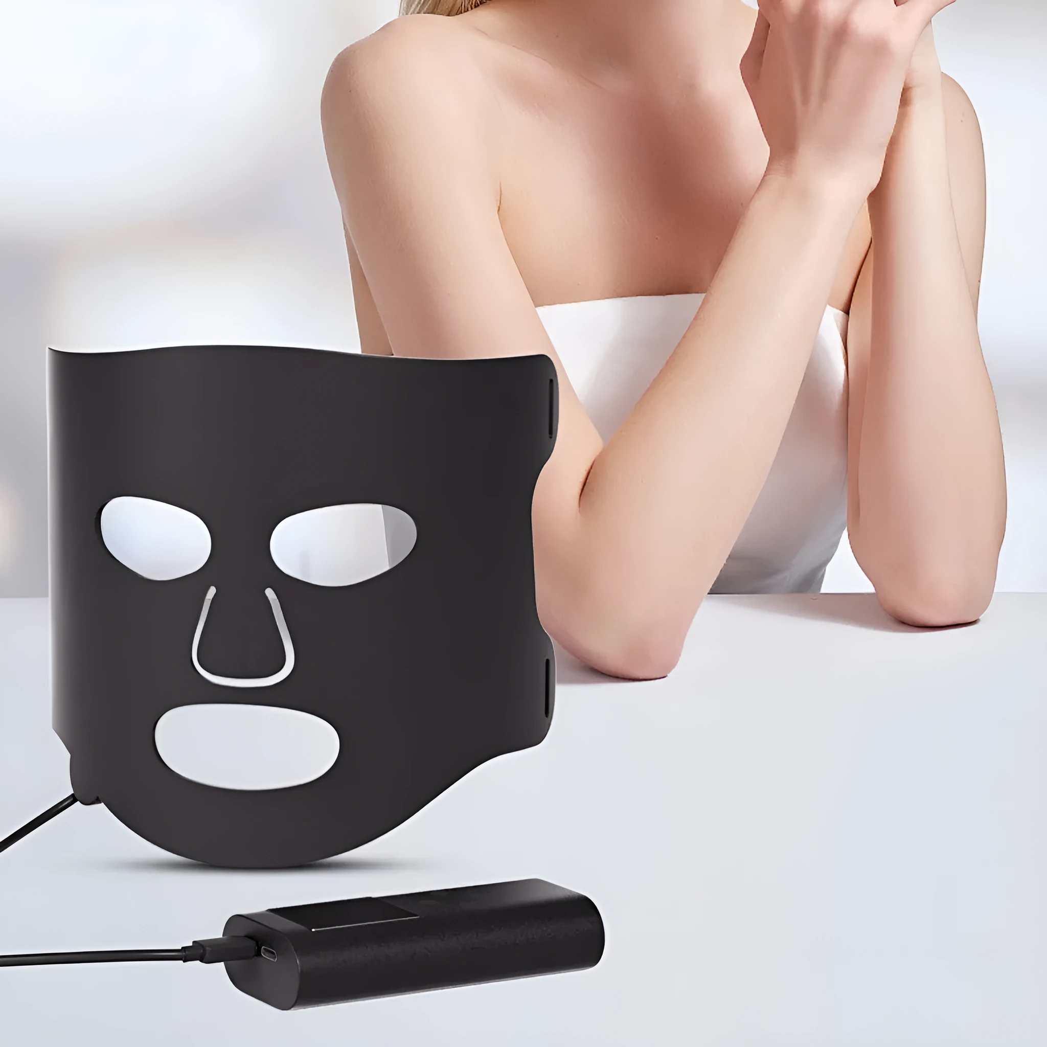 Black and gold LED phototherapy face mask with controller on a white background.