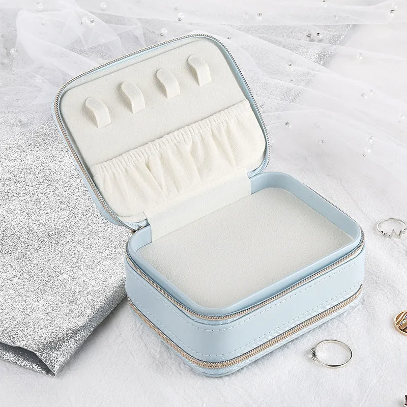 Small PU zipper jewellery box in light blue with fabric lining, 11.5x8.5x5cm, open to show rings and earrings