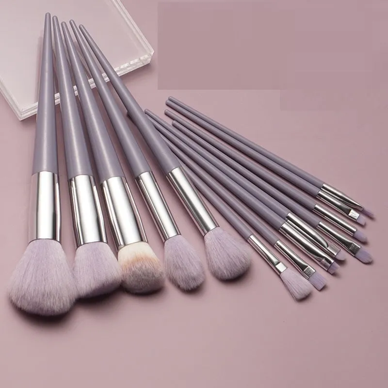 Thirteen Morandi green makeup brushes laid out, including blush and powder brushes