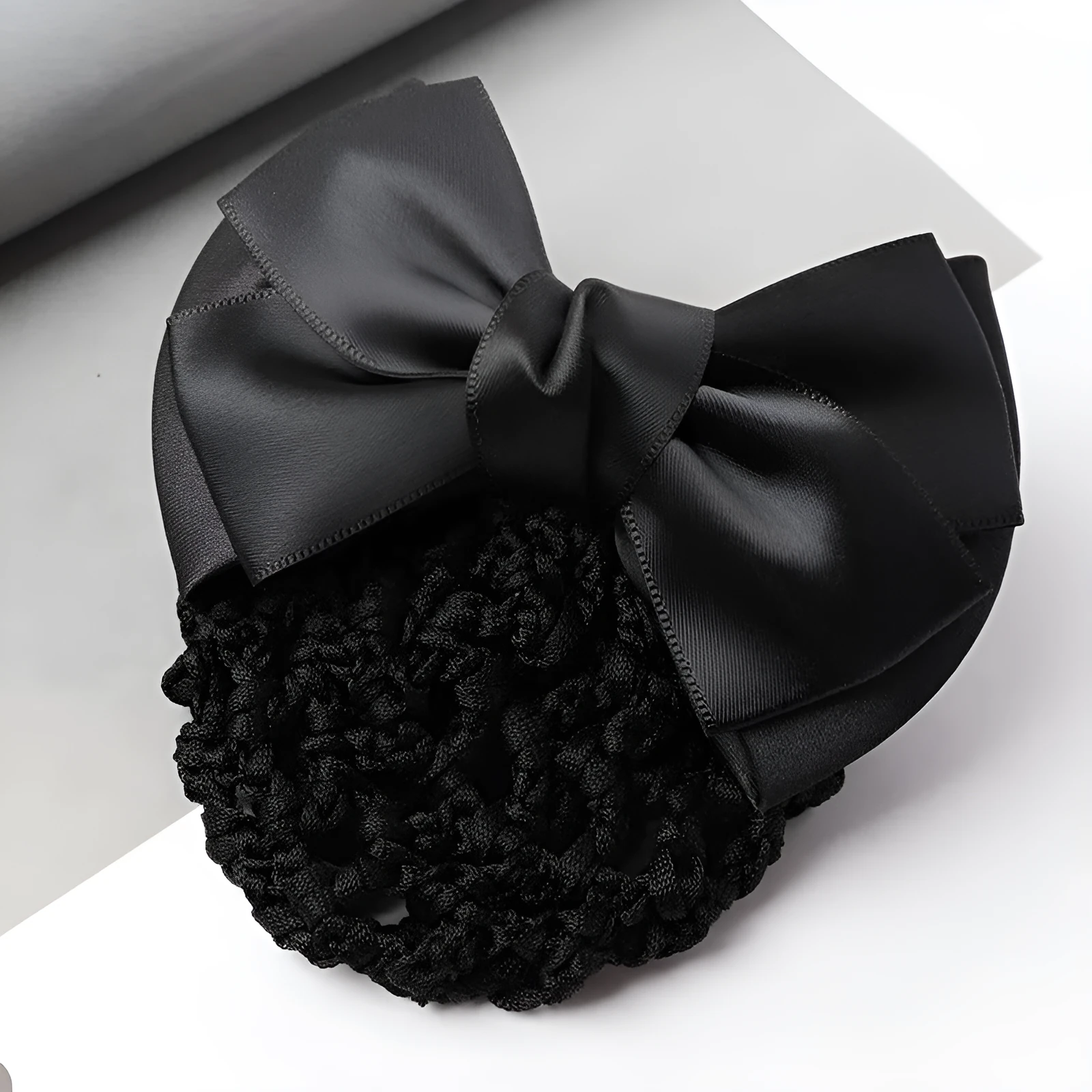 Professional hair clip ornament with a bow and net design on a hair net bag.