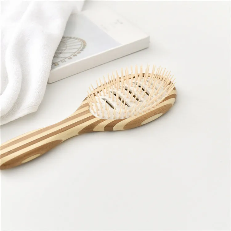 Natural bamboo scalp massage comb with round nylon teeth and rubber pad on neutral background