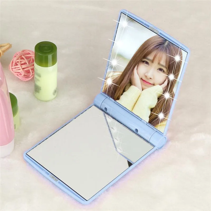 Folding LED pocket cosmetic mirror in Black, closed and open to show LEDs and compact size