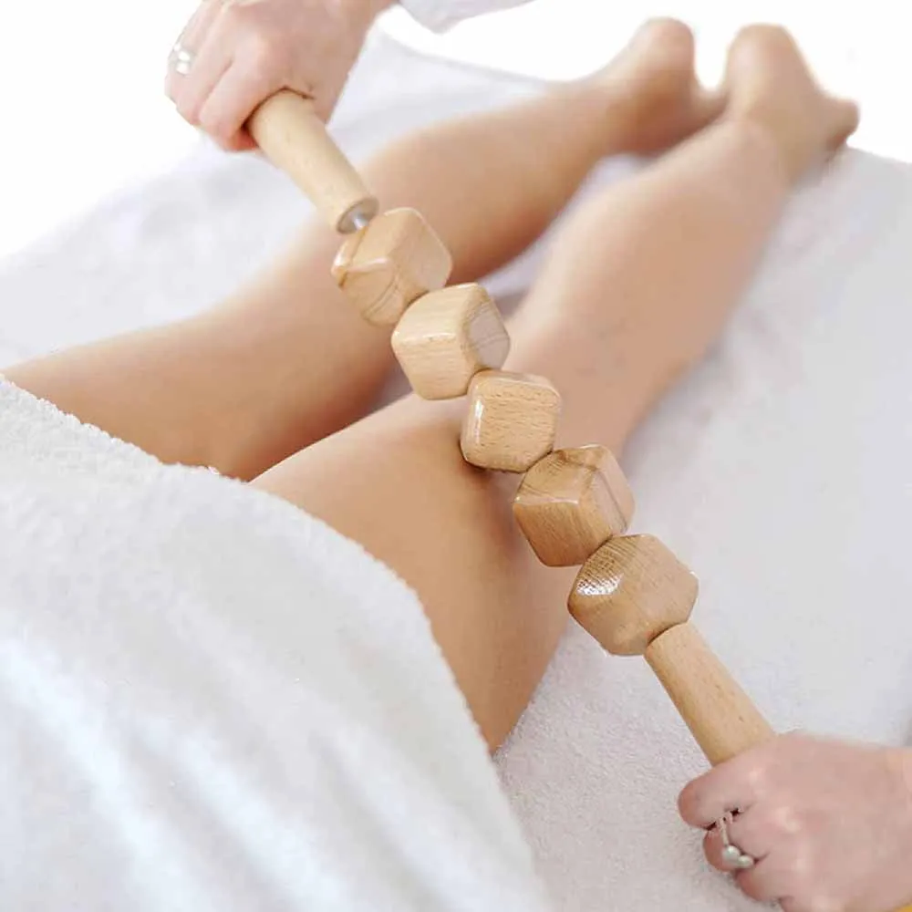 Set of three birch wood anti-cellulite massage hand rollers on a white background