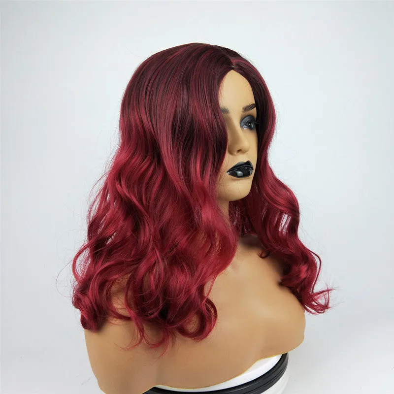 Burgundy long curly wig with gradient colour and centre bangs on a wig stand