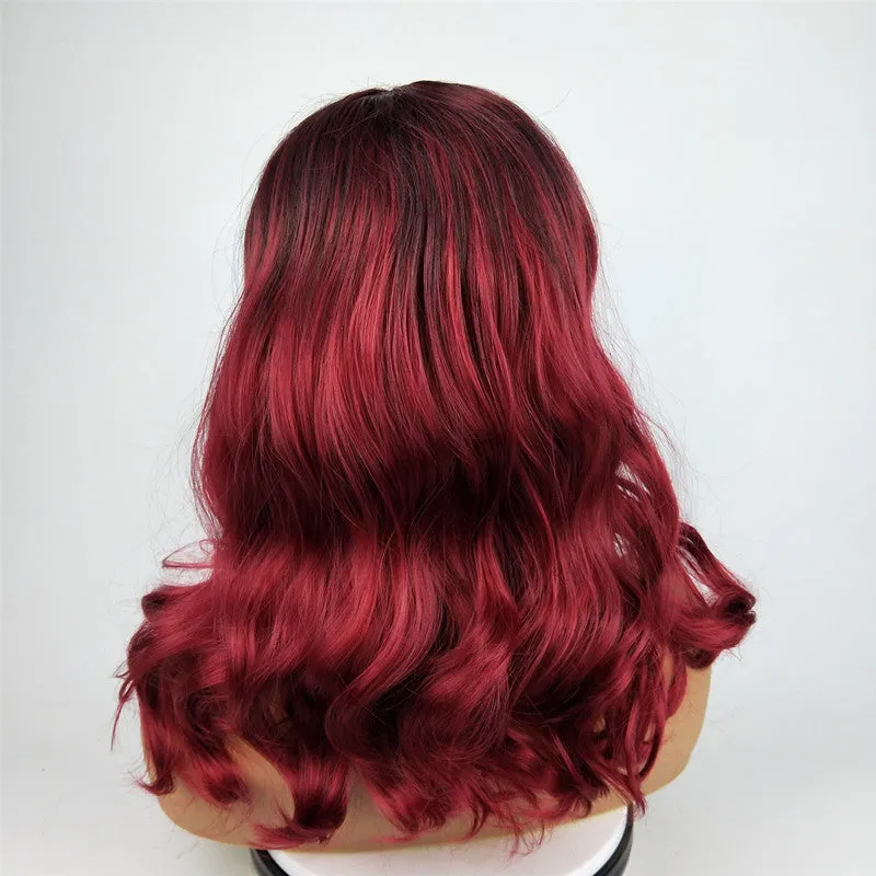 Burgundy long curly wig with gradient colour and centre bangs on a wig stand