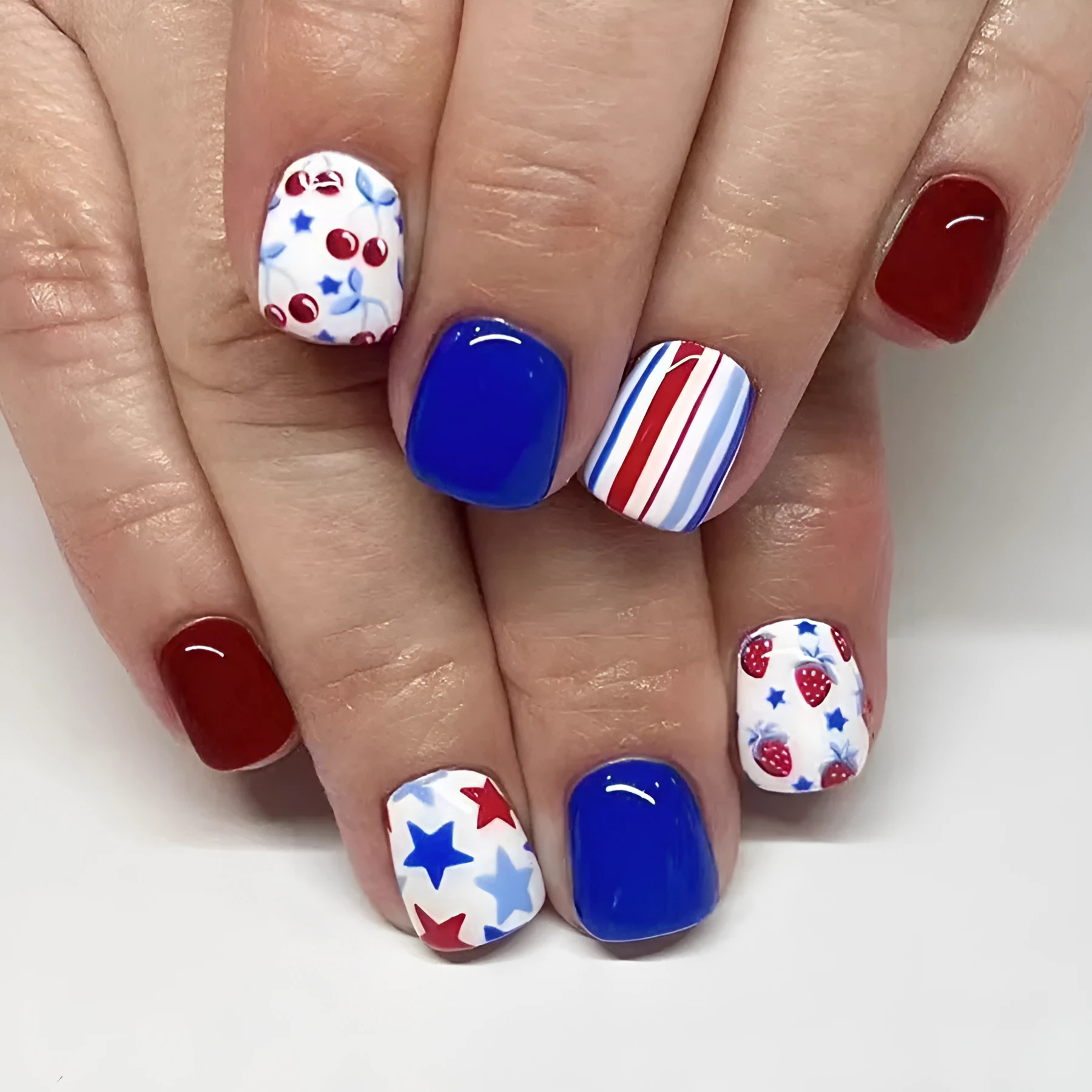 Short glossy red and blue strawberry cherry design nail stickers, 24 pieces.