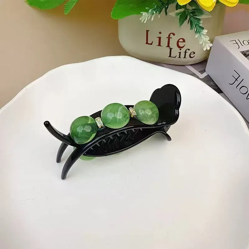 Acrylic pea barrette hair clip for women in green, shown against a dark background