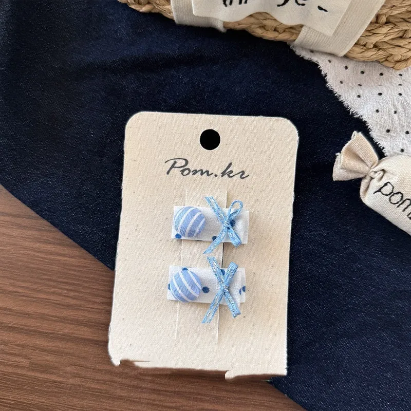 Children's denim handmade flower polka dot bow barrettes with triangle and duckbill clips on a light background