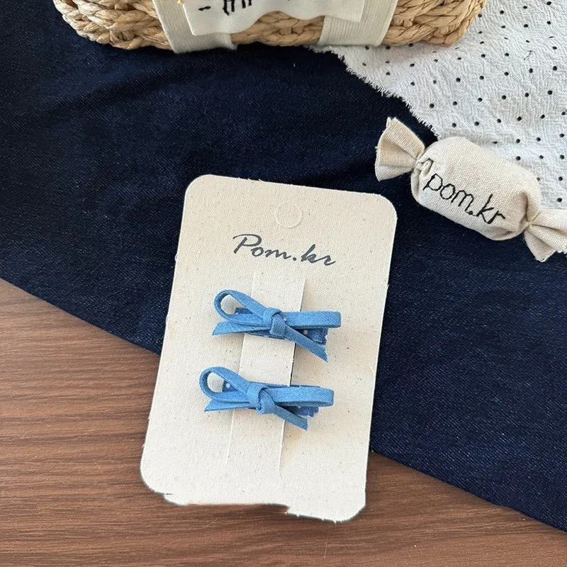 Children's denim handmade flower polka dot bow barrettes with triangle and duckbill clips on a light background