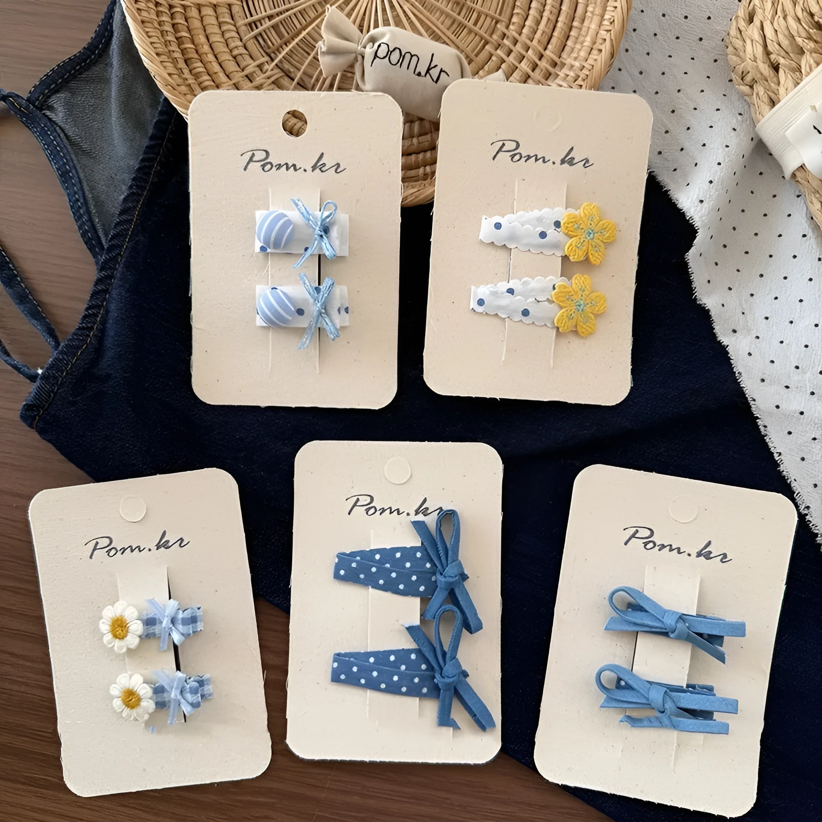 Children's denim handmade flower polka dot bow barrettes with triangle and duckbill clips on a light background
