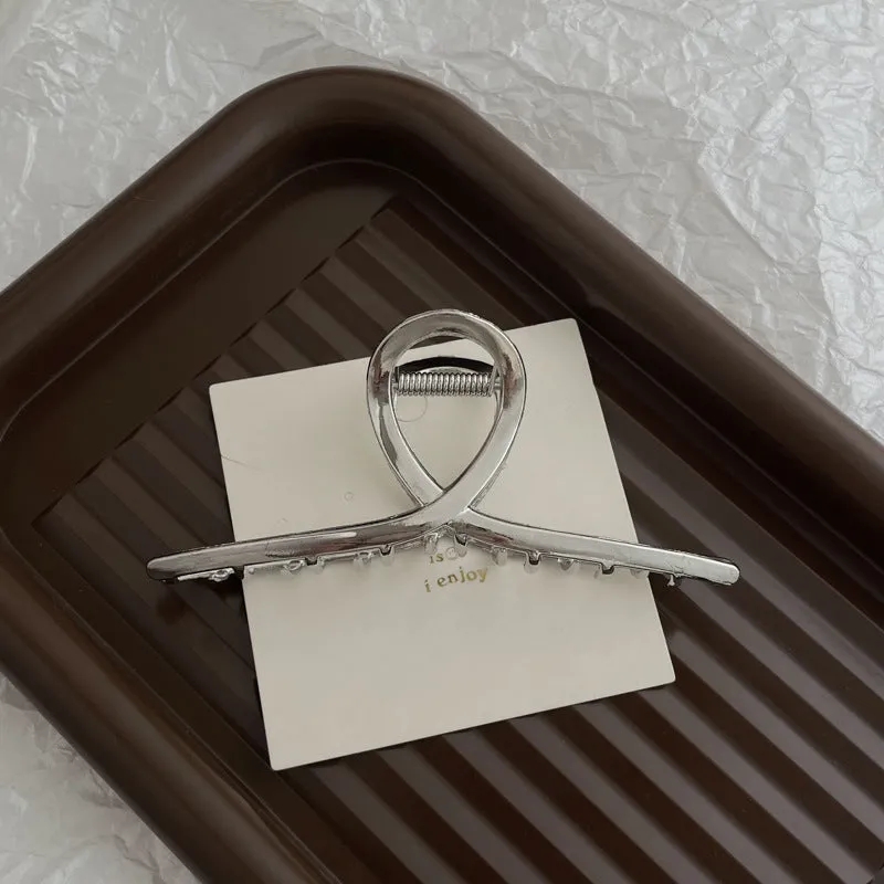 Assortment of silver metal hair barrettes and claw clips in various Korean-style designs on a white background.