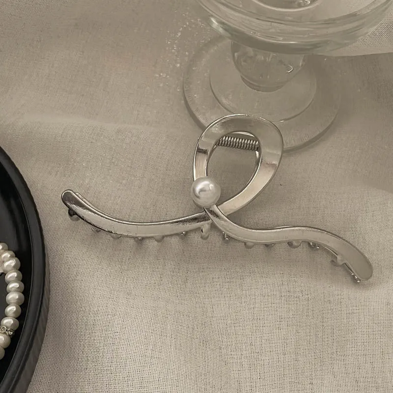 Assortment of silver metal hair barrettes and claw clips in various Korean-style designs on a white background.