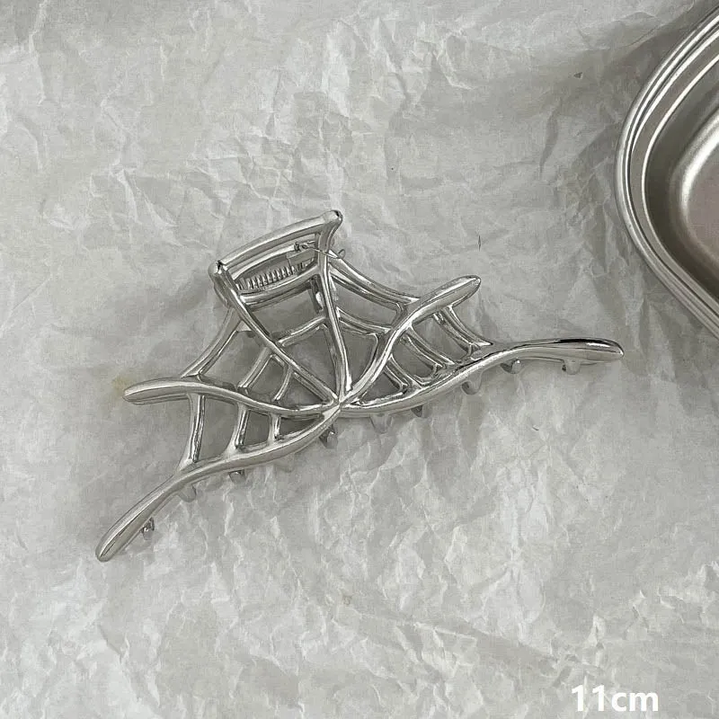 Assortment of silver metal hair barrettes and claw clips in various Korean-style designs on a white background.