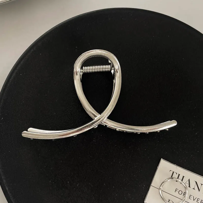 Assortment of silver metal hair barrettes and claw clips in various Korean-style designs on a white background.