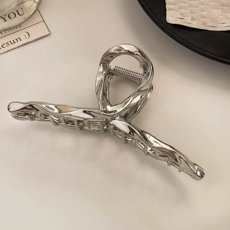 Assortment of silver metal hair barrettes and claw clips in various Korean-style designs on a white background.